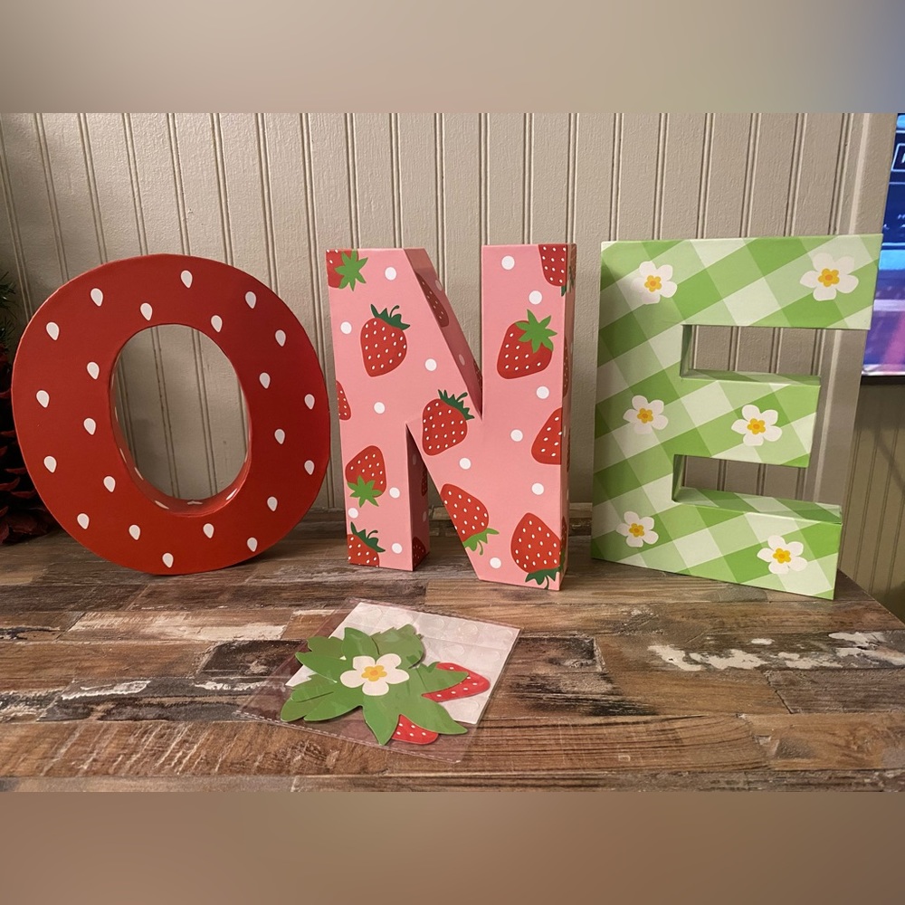 One strawberry birthday photo prop. New in box, box is beat up from shipping.